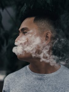 Asian American with smoke coming out of mouth
