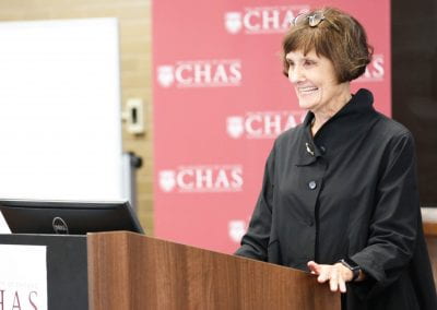 Jeanne Marsh standing at a podium and smiling at the 2019 CHAS Paris Conference